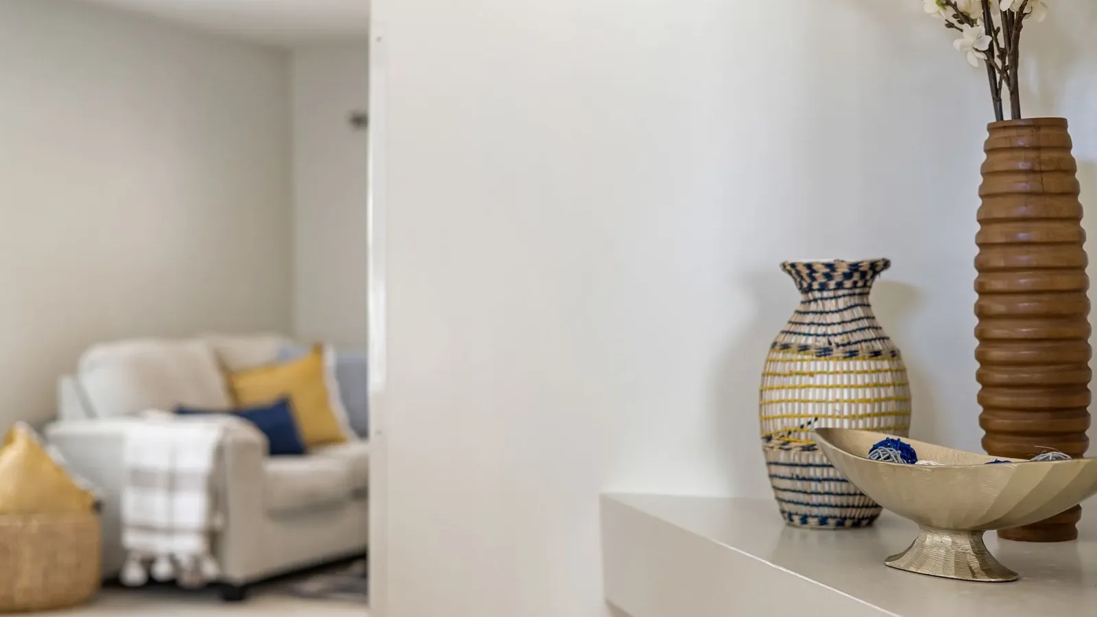 Vases décoratifs sur une étagère de salon devant un canapé