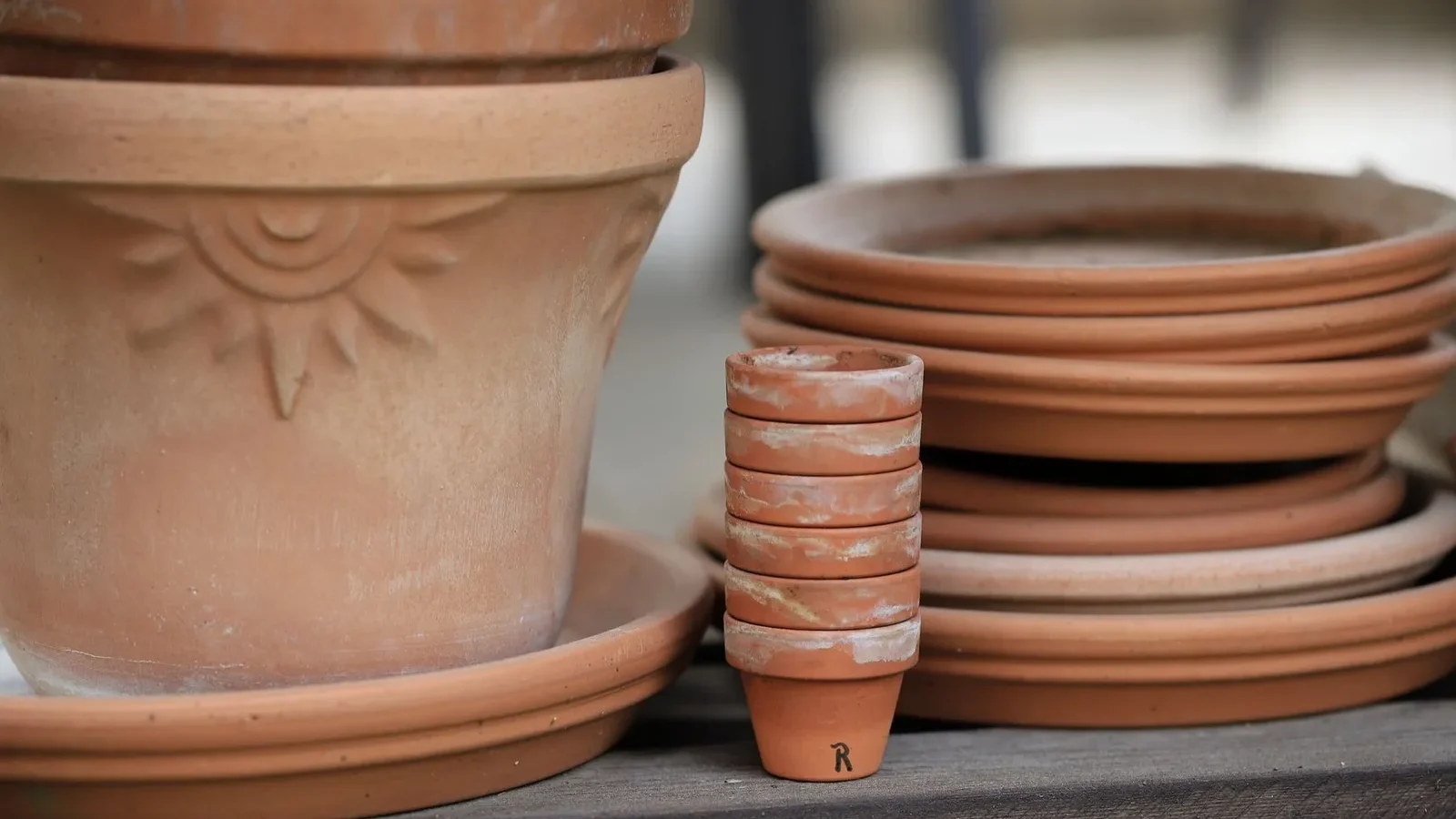 Pots en terre cuite de plusieurs tailles empilés sur une étagère